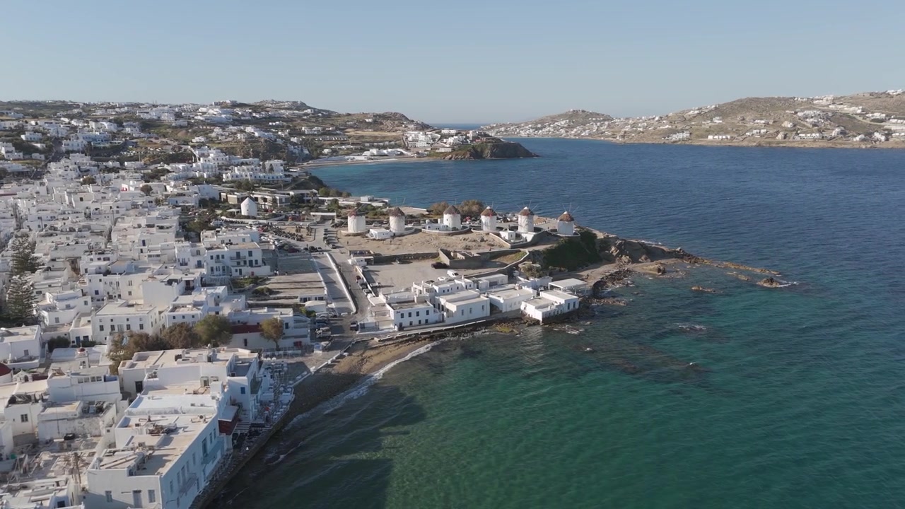 Veduta aerea degli iconici mulini a vento bianchi e della città di Mykonos, Grecia, in una giornata di sole