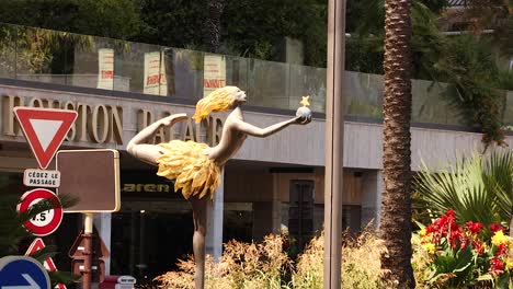 statue near traffic signs and palm trees