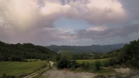 timelapse of a sunrise over green hills with cloudy sky