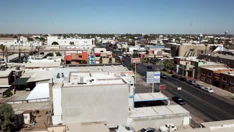 Vista-De-Un-Dron-Volando-Hacia-Atrás-Mostrando-Algunos-Edificios