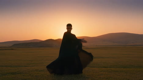man in dress in field at sunset