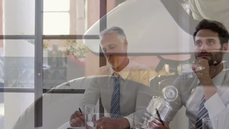 composite video of close up of wheel of a motorcycle against businesspeople having a meeting