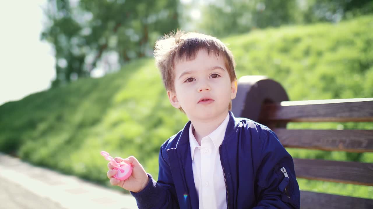 Toddler Boy Playing with Bubbles in a Park