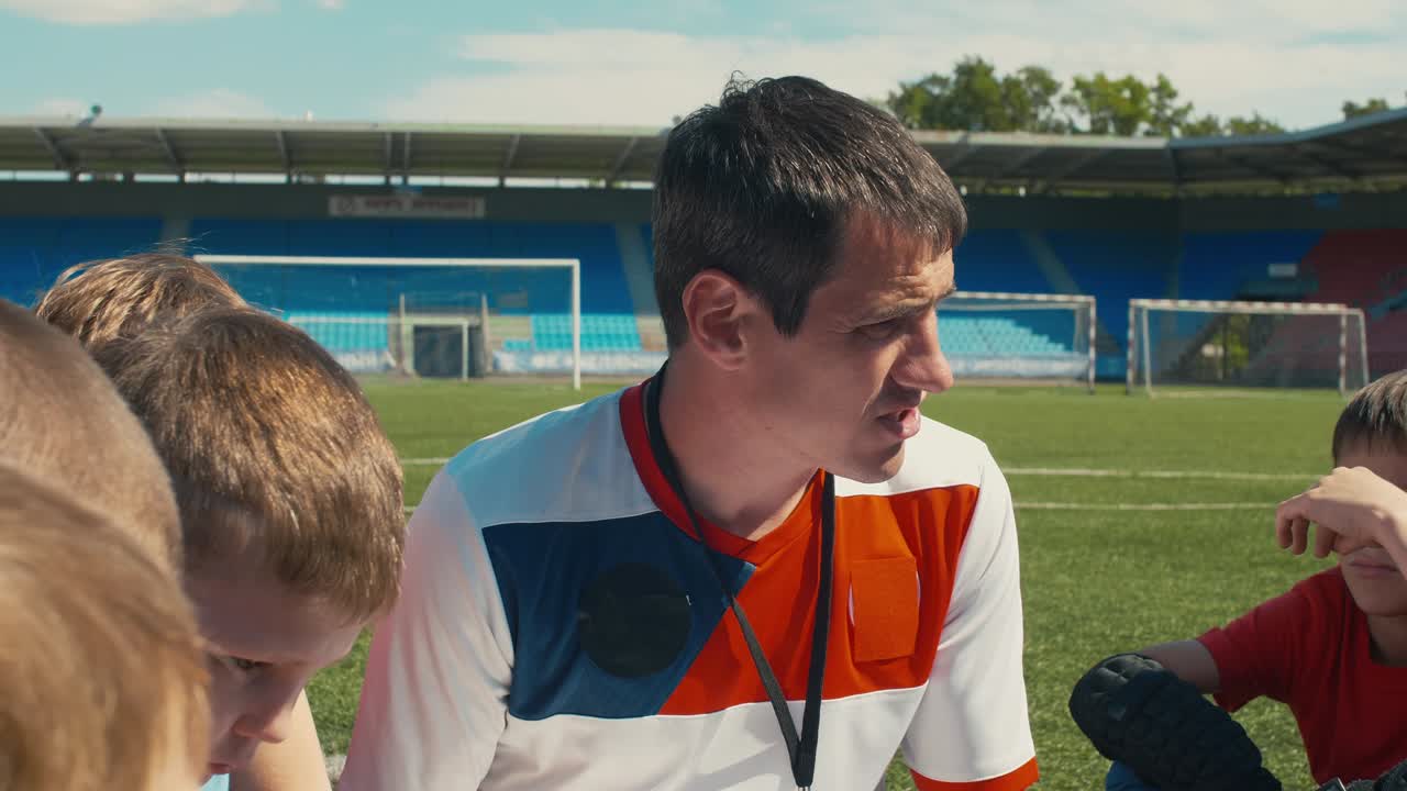 el entrenador de fútbol de yong entrena a los niños en el estadio.