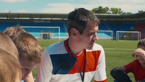 yong soccer coach training children on stadium