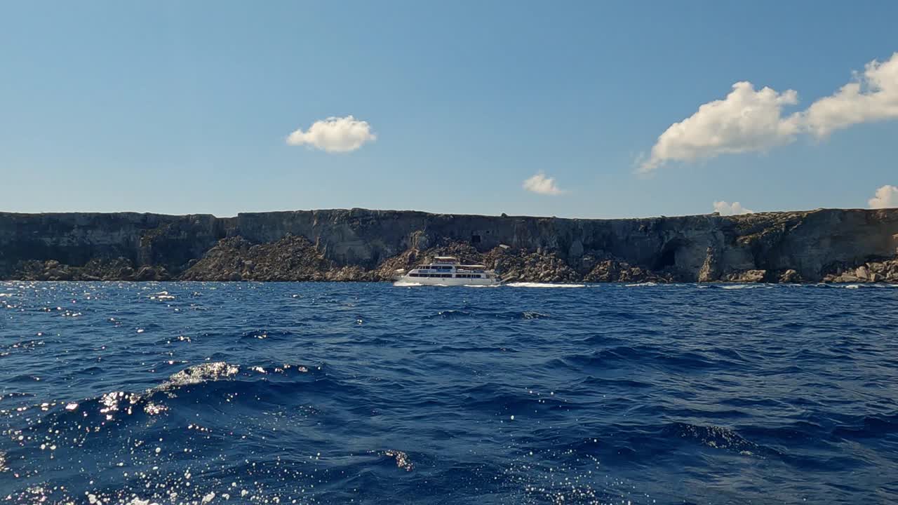 이탈리아 시칠리아의 파비냐나 섬 해안을 따라 항해하는 관광 보트의 범선에서 낮은 각도의 해수면 전망