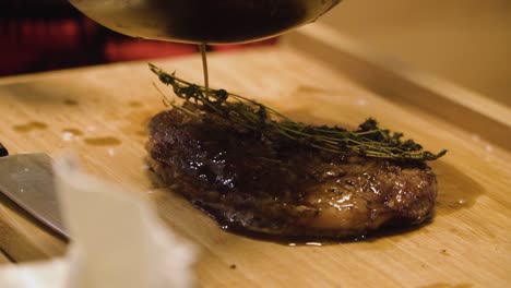 pouring brown sauce onto freshly cooked a4 wagyu steak garnished with thyme