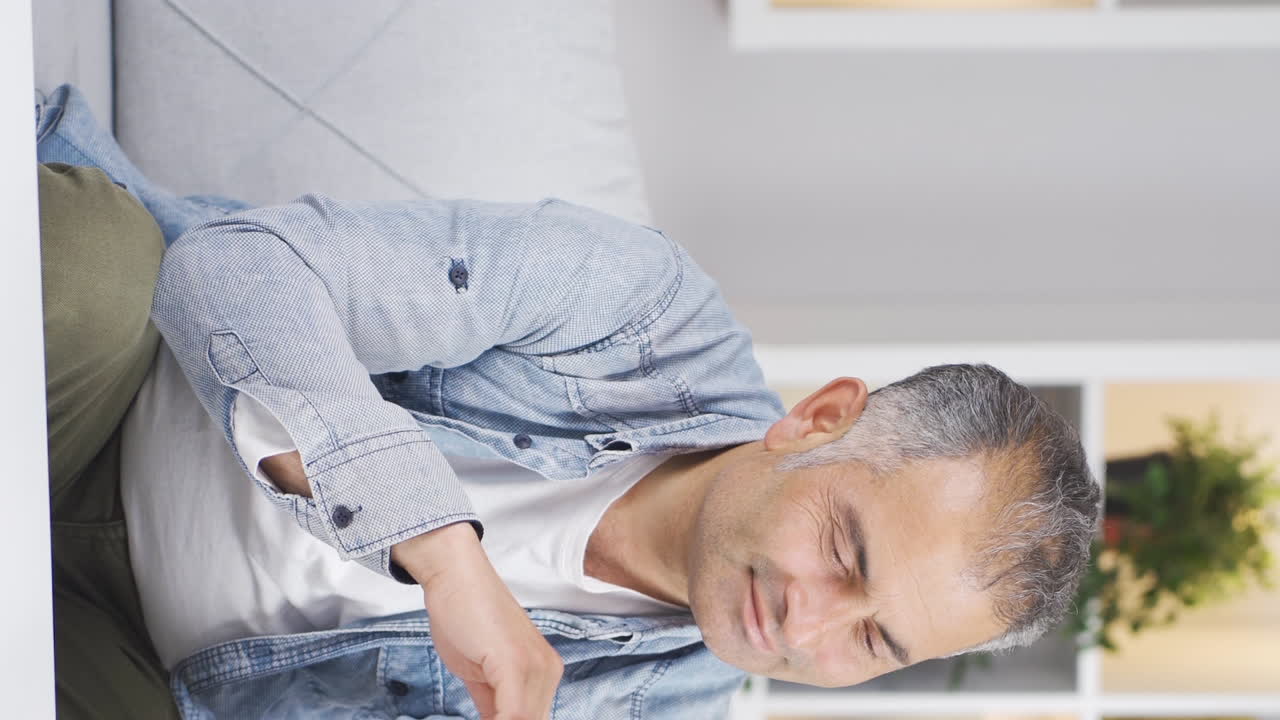 vídeo vertical del hombre con anhelo mira la foto en el teléfono.