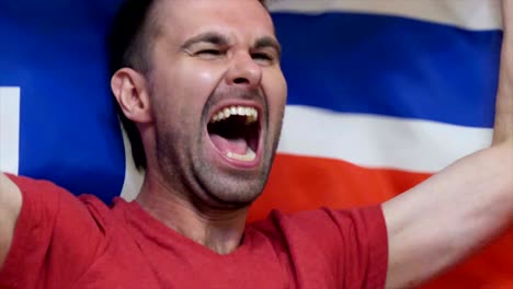 fanático noruego celebrando mientras sostiene la bandera de noruega en cámara lenta, 4k, de alta calidad