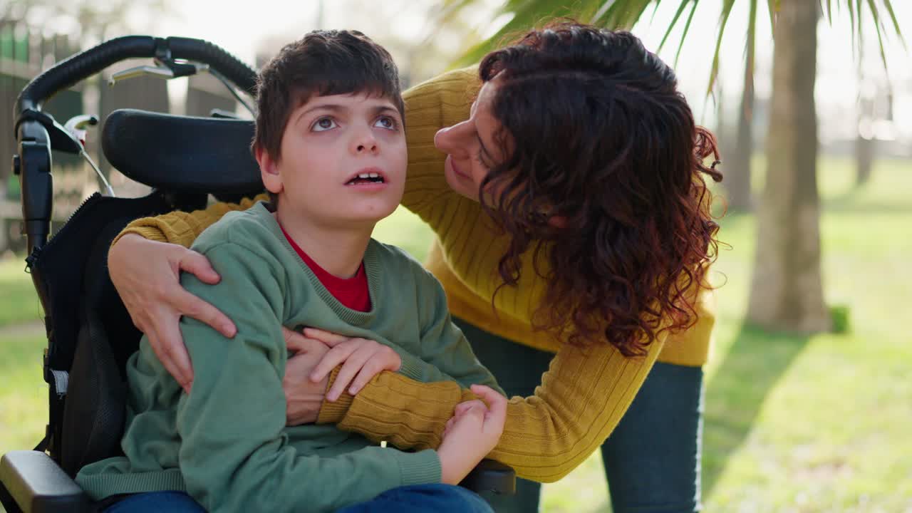 A mother embraces her child with a disability in a wheelchair