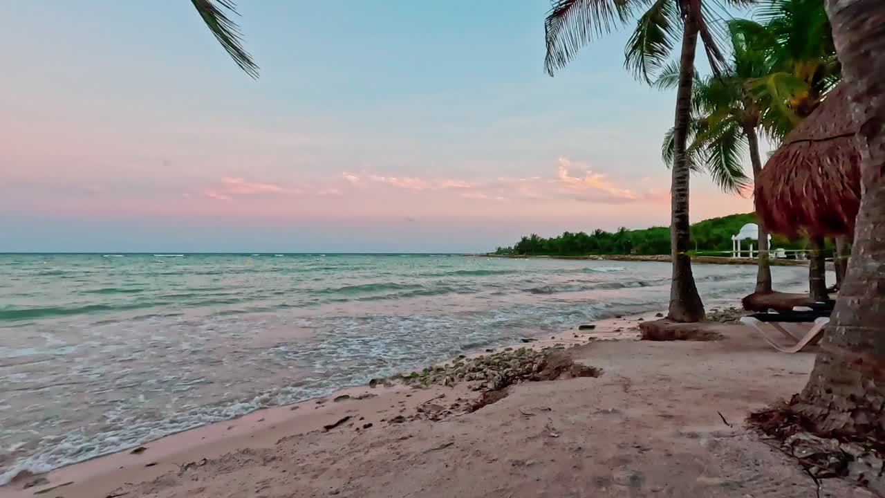 hiperlapso de tulum mexico y el mar caribeño con palma balanceándose en la brisa y timelapse de olas rompiendo en la orilla al atardecer
