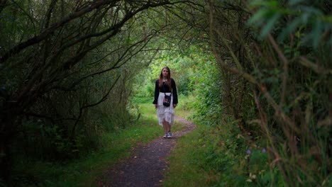 Young-Girl-Walking-Peacefully-Through-Trees-Pathway-In-Rural-Area