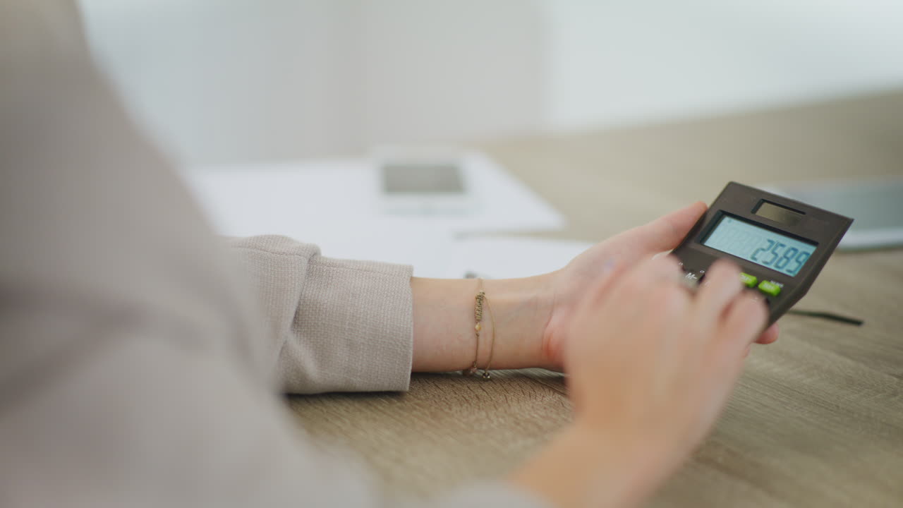 여성은 계산기를 사용하고 계산합니다.