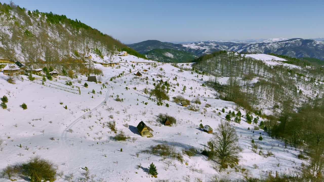 Paesaggio invernale di montagne innevate con baite tradizionali