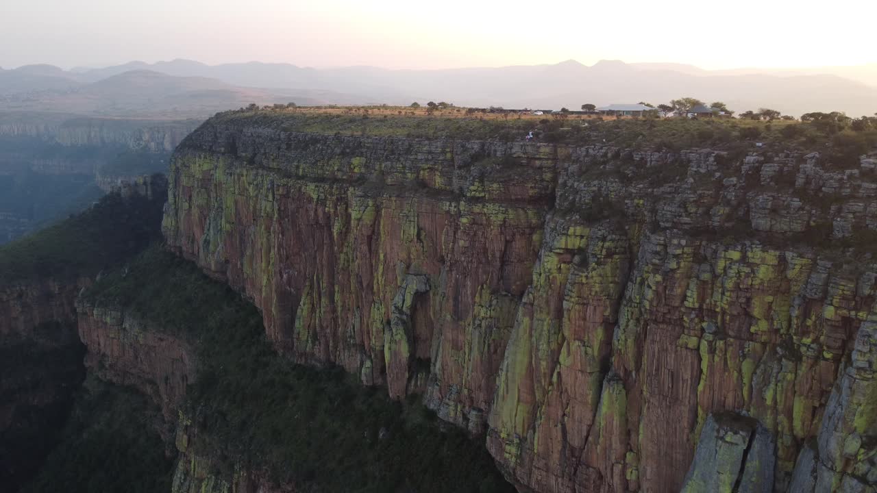 vista aérea cinematográfica del borde del acantilado de la montaña drakensberg con la luz dorada del atardecer en el fondo