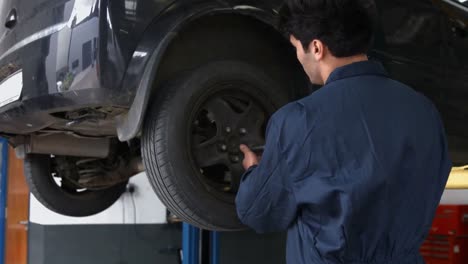 Handsome-mechanics-repairing-a-car