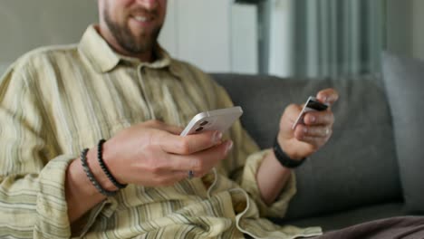 hombre usando teléfono inteligente y tarjeta de crédito para el pago en línea