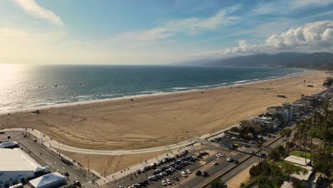 Strand-Mit-Sandbergen-Und-Einigen-Fahrenden-Autos-In-Santa-Monica,-Ca