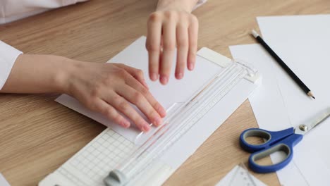 close-up of hands using a paper cutter