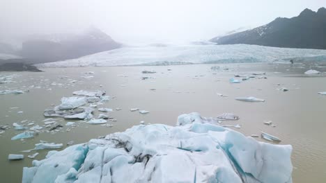 Cinematic-Drone-Shot-of-Large-Iceberg-with-Glacier-in-Background