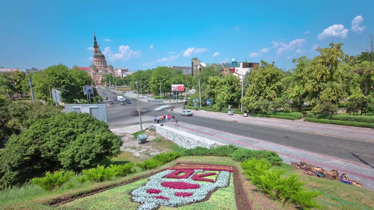 Timelapse da Catedral da Anunciação, com canteiro de flores em um dos principais pontos turísticos. Tráfego na rua. É uma das igrejas ortodoxas mais altas, com seu portão decorado com cúpula dourada em forma de cebola e ícones, Carcóvia, Ucrânia.