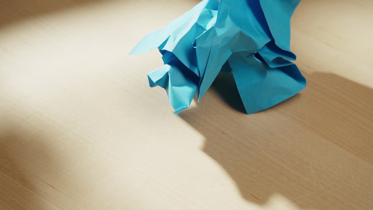 Folding blue paper with hands