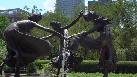 closeup view of a water fountain and sculpture against the new york city skyline