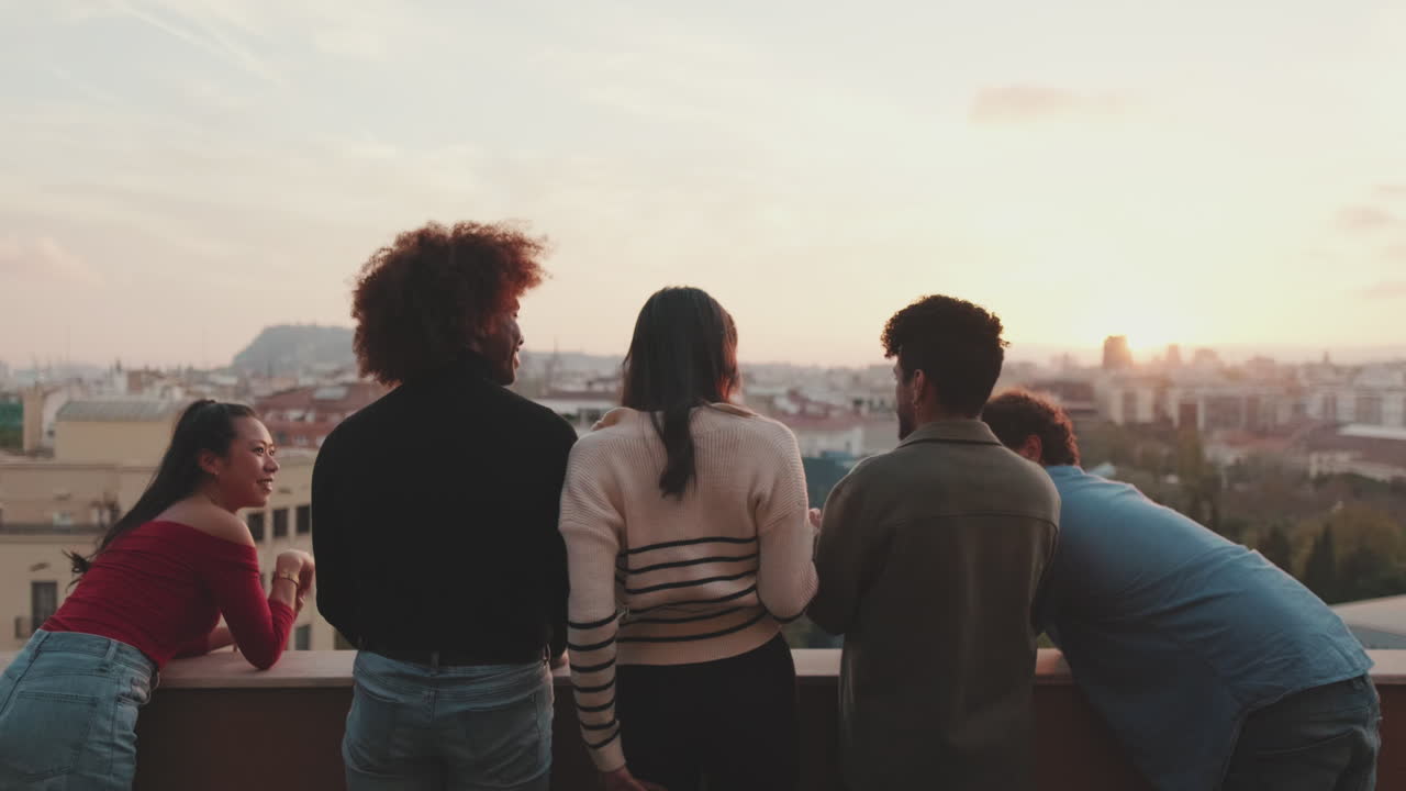 Gruppo di amici che si godono il tramonto su un tetto