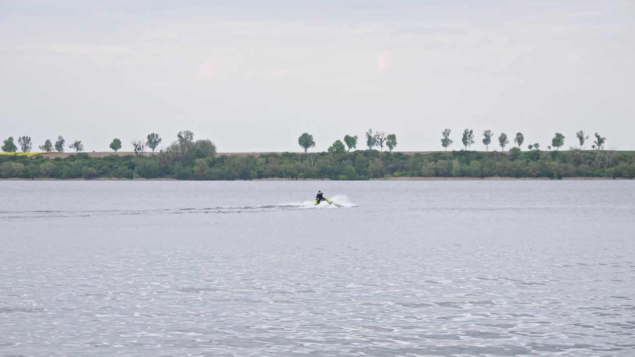 una lancha rápida maniobrando a través del lago, creando una salpicadura de agua blanca a su paso - amplia toma en cámara lenta