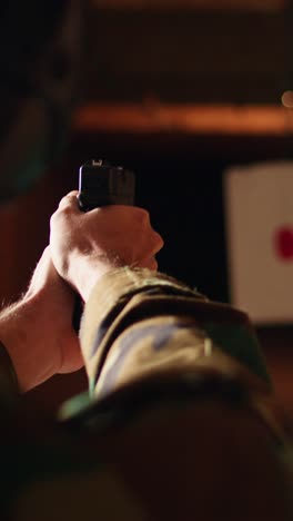 Vertical video Man holding gun enjoying recreational indoor shooting, close up