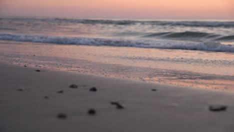 waves reaching the coast at sunset in slow motion