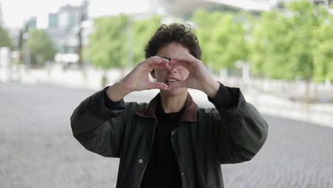 Woman-showing-hand-heart-and-looking-at-camera