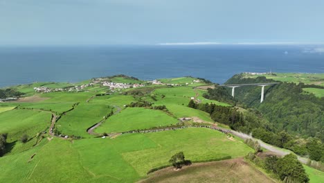 aerial downhill view of rally car racing downhill on dusty mountain road during tour european rally, graminhais stage, azores