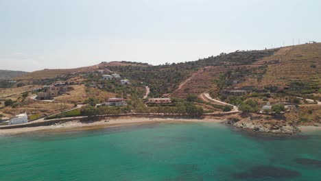 órbita aérea alrededor de la hermosa playa turquesa y las colinas de la isla griega