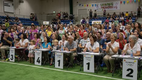 enthusiastic crowd cheers at a vibrant event, celebrating moments of joy and community during a fun gathering with participants and spectators