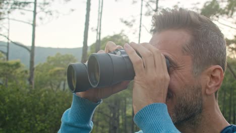 happy man admiring nature through binoculars