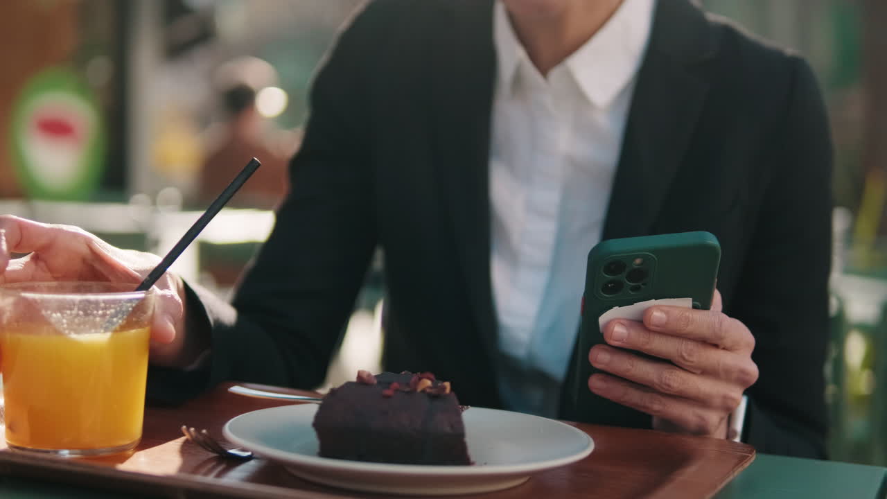 Woman Drinking Juice and Using Smartphone at Outdoor Cafe