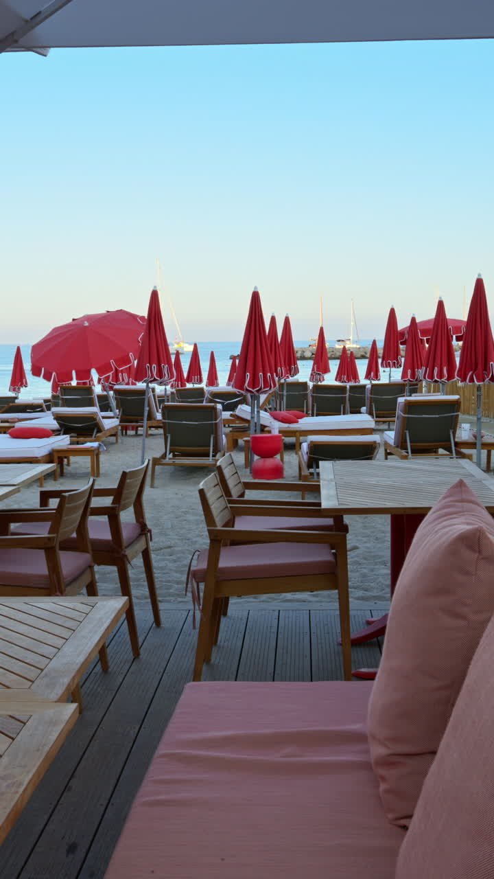 Close up of tables at a restaurant on the beach in the evening. Vertical