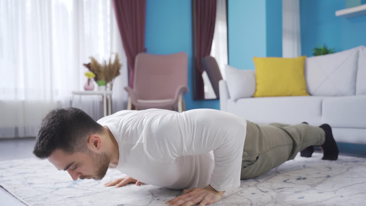 집의 거실에서 부시를 하는 젊은 남자. 집에서 운동하는 운동선수 젊은 남자.