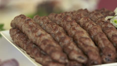 armenian lula kebab served on decorative platter with chopped onion