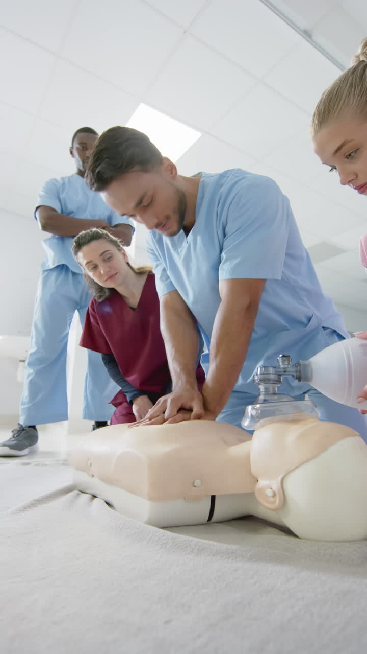 Vertical video of latino doctor training trainee doctors in cpr procedure using dummy, slow motion
