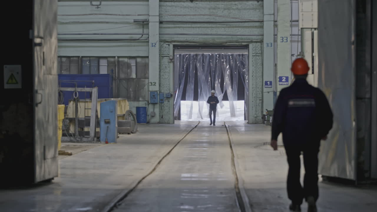 Worker walking through industrial factory interior