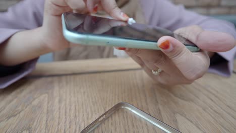 a woman cleaning her phone screen with a cleaning cloth.