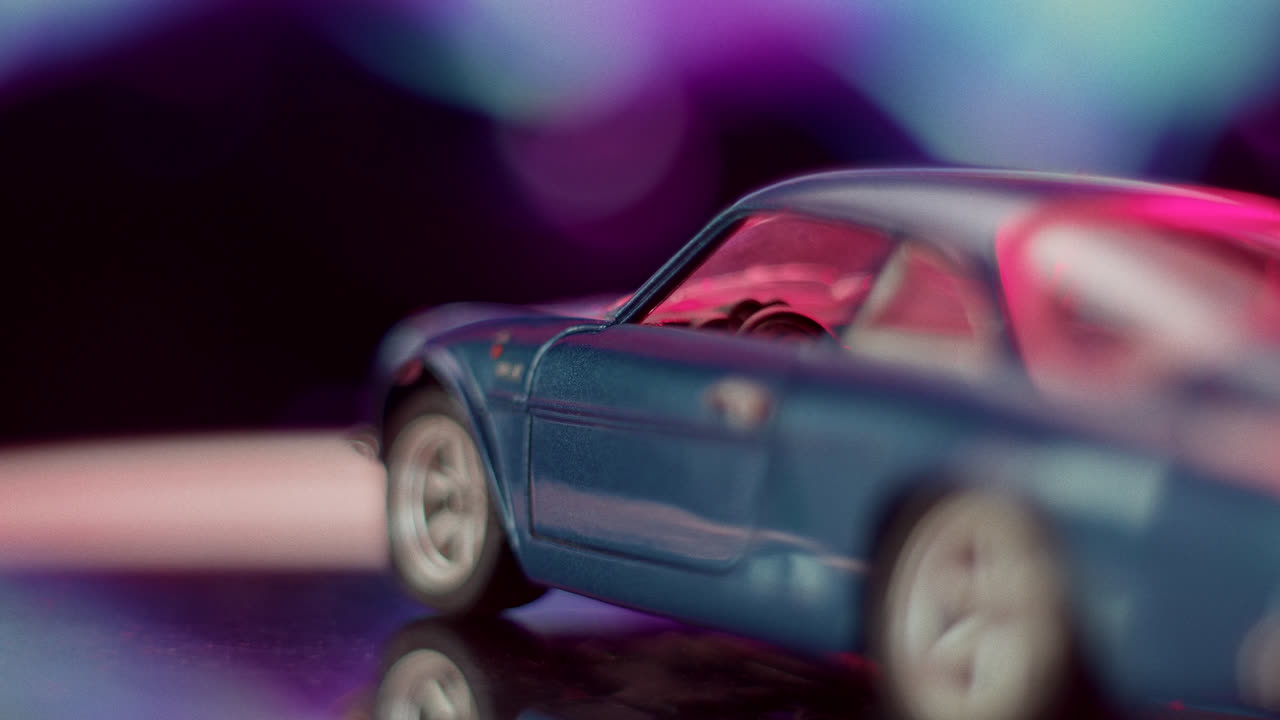 Close-up of a blue toy car with a neon-lit background