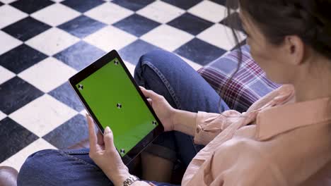 woman using a tablet with green screen