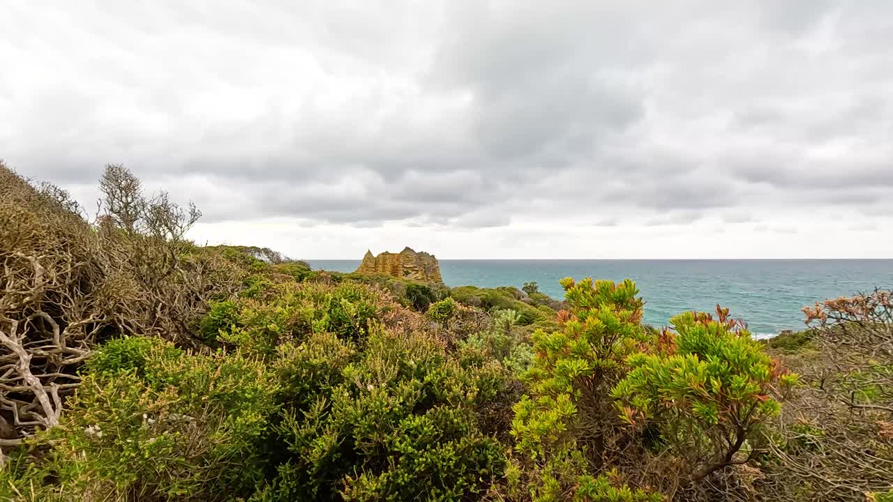 Panoramic view of lush coastal vegetation and ocean under cloudy skies at Aireys Inlet, Victoria