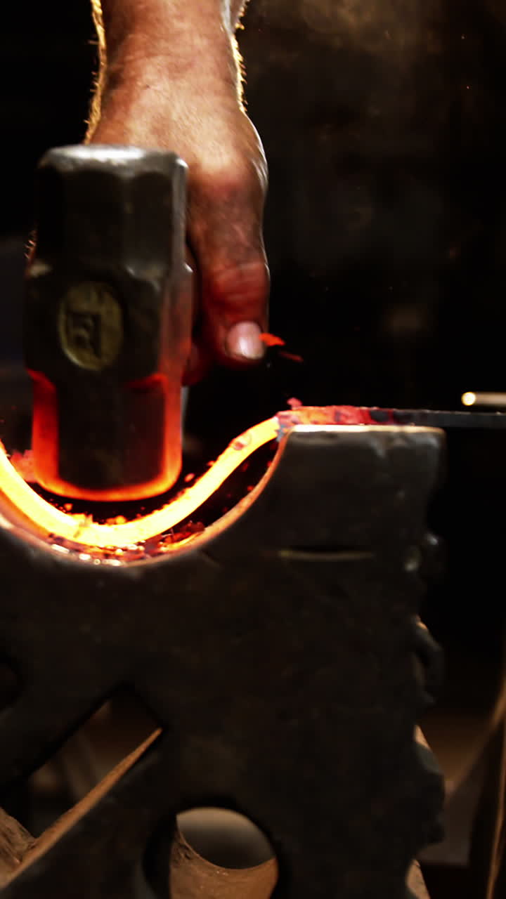 Mid-section of blacksmith working on a iron rod