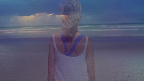 animation of landscape with ocean over caucasian woman at beach