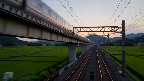 high-speed train in japanese rural landscape at sunset