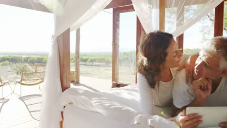 happy couple using digital tablet on bed 4k